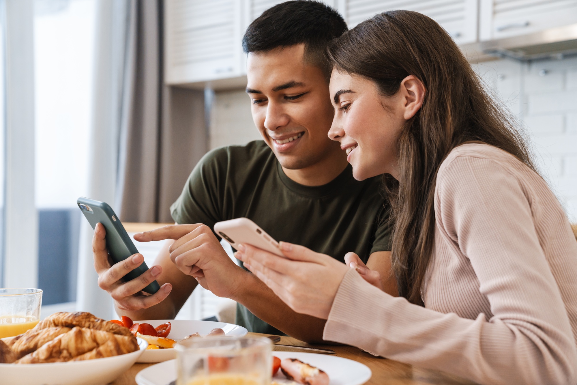 Happpy young attractive couple using mobile phones