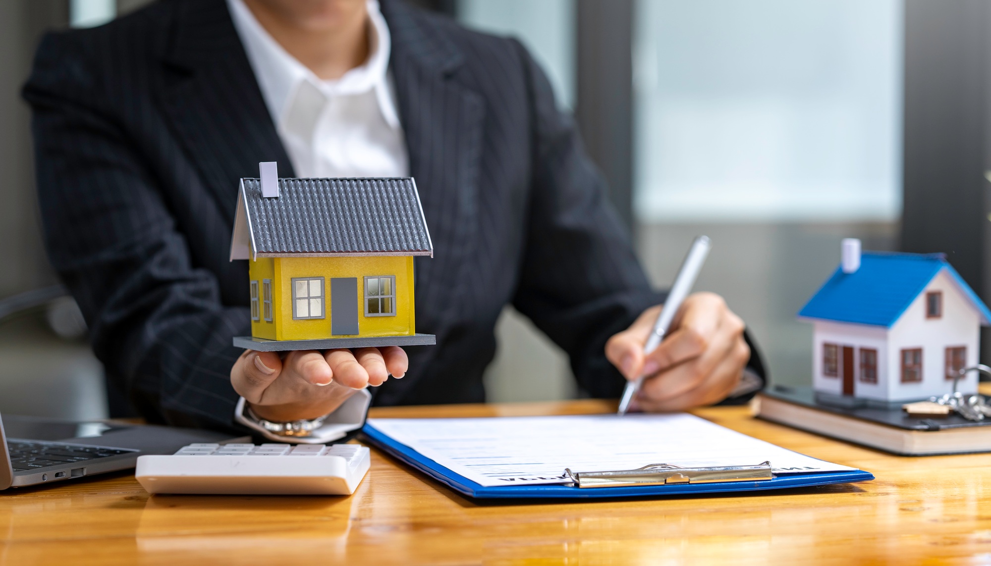Real estate agents offer model homes with contracts for sale and purchase of houses and land. home m